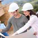 Gothaer Bauherrenhaftpflicht: Junges Paar auf einer Baustelle vor einem unfertigen Haus.